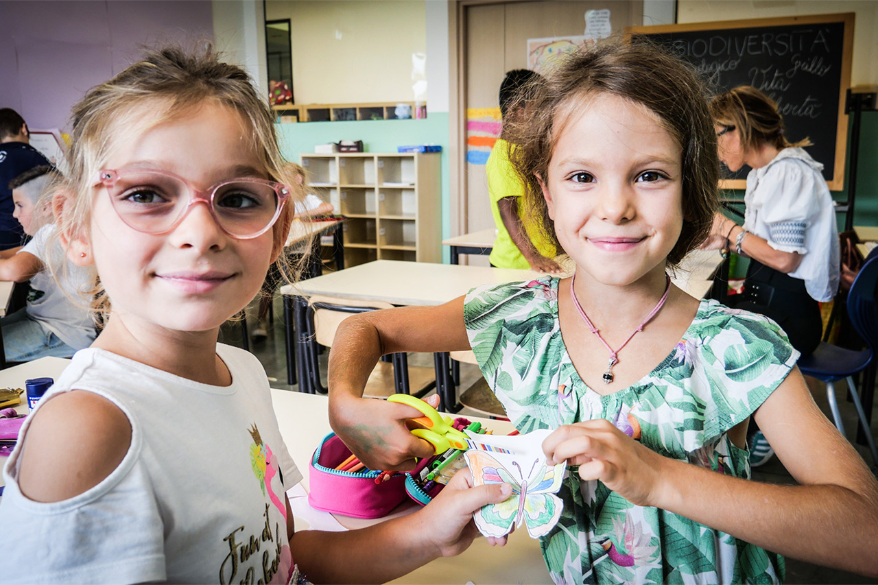 AIS Assisi International school, due ragazze mostrano il disegno di una farfalla mentre sono in classe